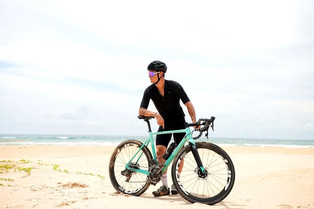 Cyclist on Sri Lankan beach at sunset